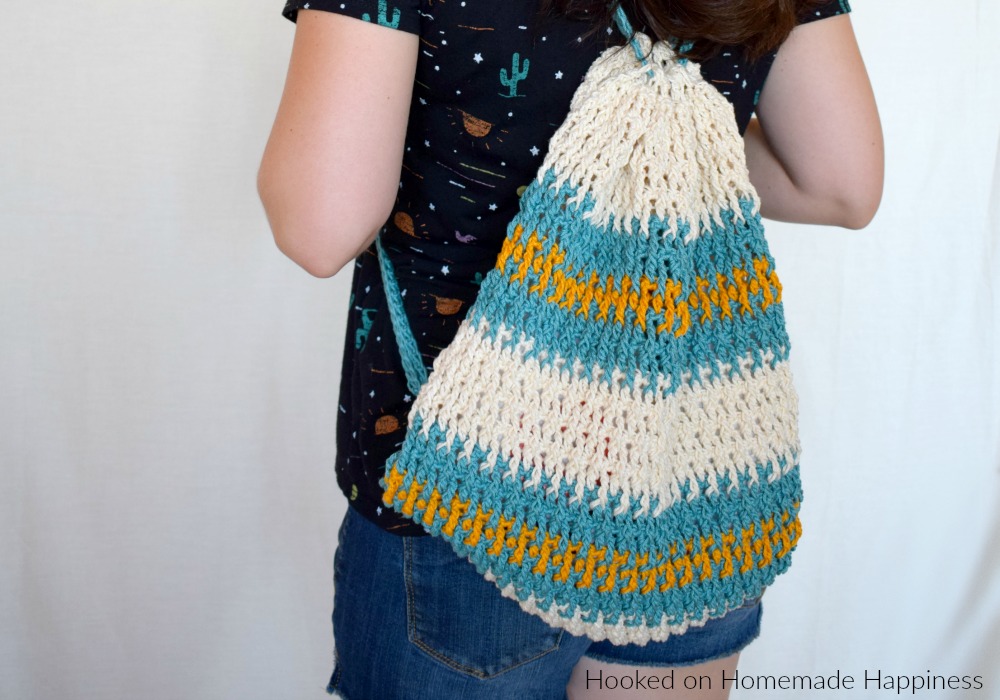 Daytrip Cinch Backpack Crochet Pattern - The Daytrip Cinch Backpack Crochet Pattern is perfect for your next outing! It's made of durable cotton, with a solid stitch, and can hold all the things you might need. #crochet #freecrochetpattern #crochetbag