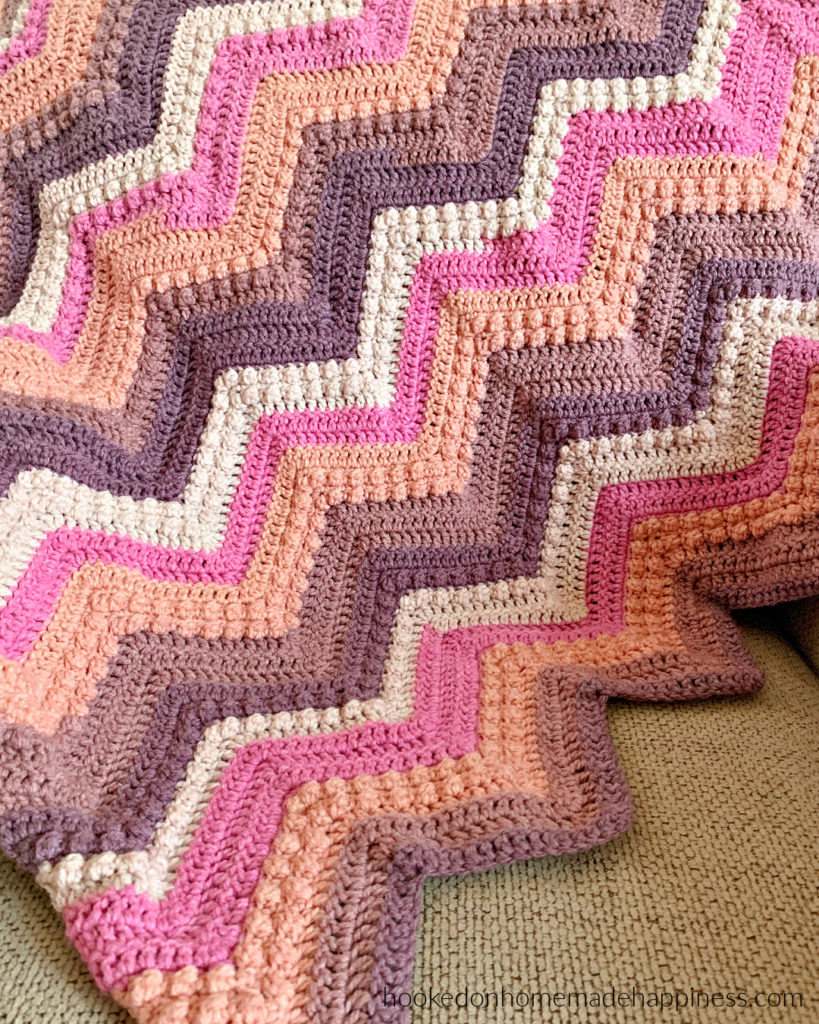 Raspberry Baby Blanket Crochet Pattern - The Raspberry Baby Blanket Crochet Pattern has a classic chevron stripe pattern with some fun berry stitches mixed in!