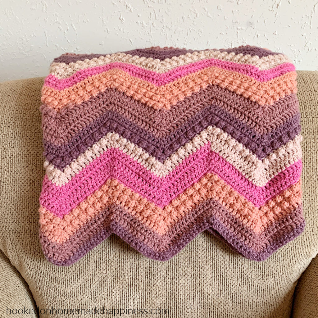 Raspberry Baby Blanket Crochet Pattern - The Raspberry Baby Blanket Crochet Pattern has a classic chevron stripe pattern with some fun berry stitches mixed in!