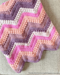 Raspberry Baby Blanket Crochet Pattern - The Raspberry Baby Blanket Crochet Pattern has a classic chevron stripe pattern with some fun berry stitches mixed in!