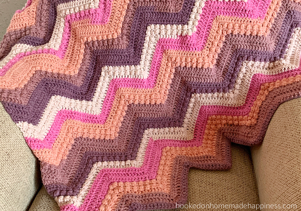 Raspberry Baby Blanket Crochet Pattern - The Raspberry Baby Blanket Crochet Pattern has a classic chevron stripe pattern with some fun berry stitches mixed in!