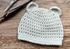 Baby Bear Beanie Crochet Pattern - The Baby Bear Beanie Crochet Pattern is a simple beanie pattern with cute little ears added. This beanie works up in no time! Perfect to add to your donation pile.